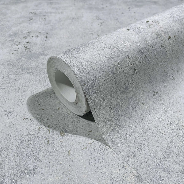 Marburg City Glow 34267 Close-up of a gray textured wallpaper roll resting on the same pattern, showing a mottled concrete-like design with fine speckling.