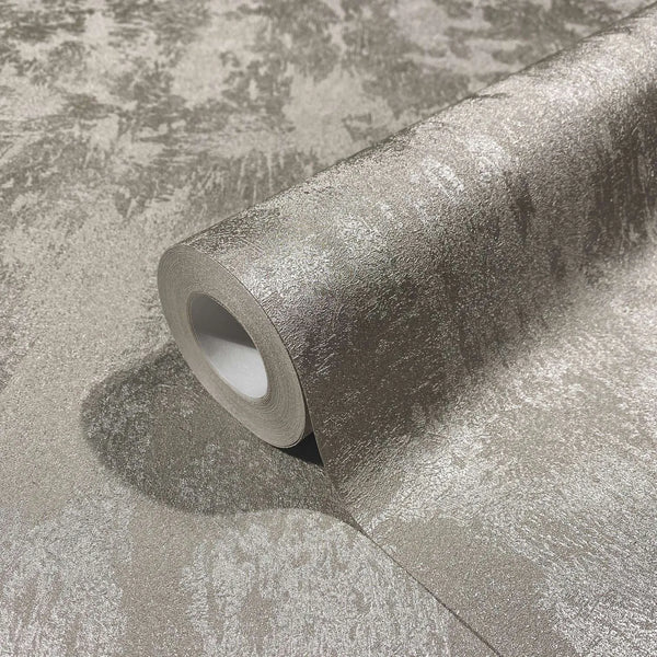 Marburg City Glow 34274 Close-up of a wallpaper roll resting on a matching unrolled sheet, showing a mottled gray pattern with a subtle pearlescent sheen.