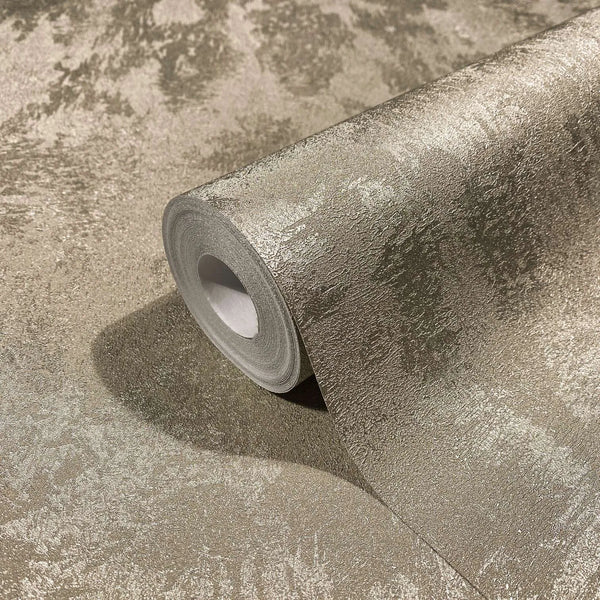 Marburg City Glow 34276 Close-up of a wallpaper roll resting on the same wallpaper, showing a mottled textured surface with a metallic sheen.