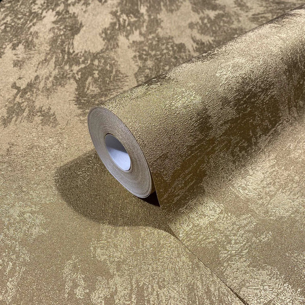 Marburg City Glow 34280 Close-up of a gold textured wallpaper roll resting on the same pattern, showing an irregular mottled finish with a soft sheen.