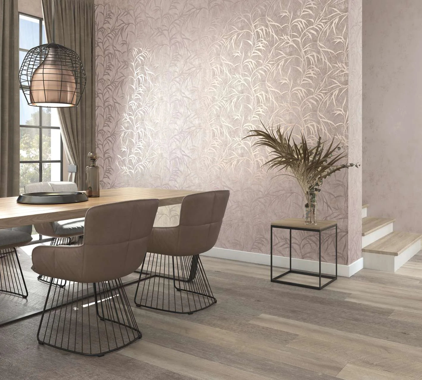 Marburg City Glow 34285 Dining room scene featuring a feature wall in metallic leafy-frond wallpaper on a muted taupe backdrop, behind a wood dining table with upholstered wire-base chairs, a caged pendant light, curtains by a window, a small side table with a glass vase of dried spr.