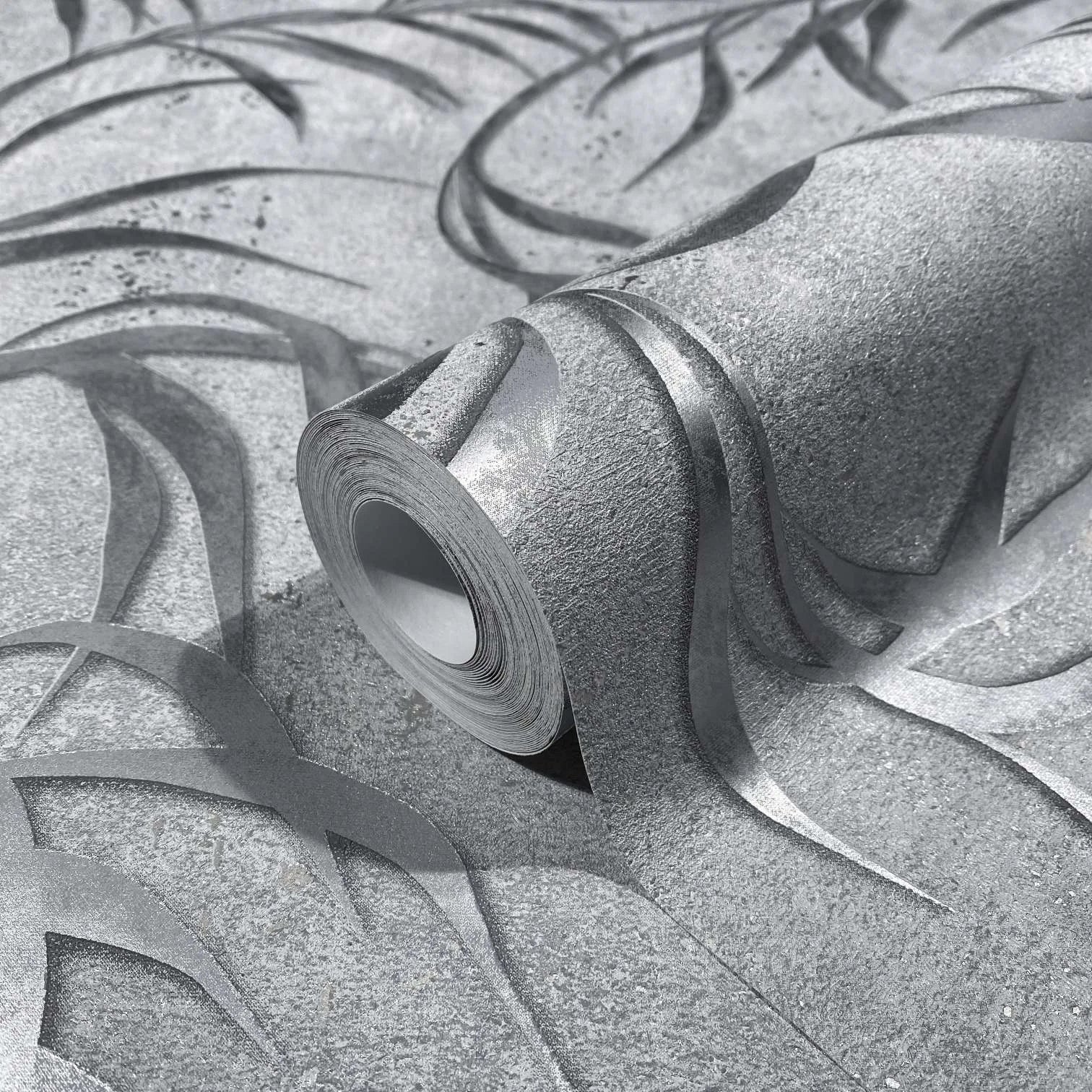Marburg City Glow 34287 Close-up of a wallpaper roll resting on matching wallpaper, showing an abstract curved ribbon pattern with raised detailing in gray and silver tones.