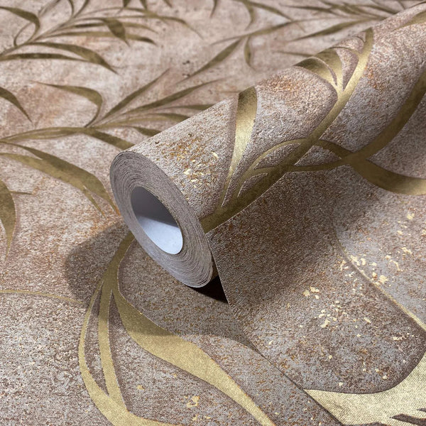 Marburg City Glow 34288 Close-up of a wallpaper roll resting on the same pattern, showing a mottled brown background with sweeping gold curves and leaf-like shapes.
