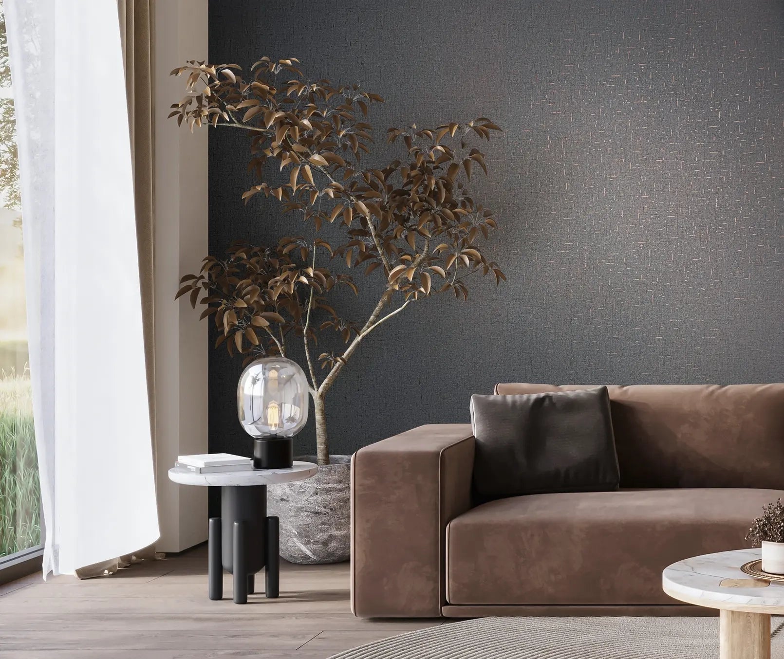 Marburg City Romance 35111 Dark gray wallpaper with a small scattered dash pattern forms the backdrop to a living room scene with a brown sofa, a round side table holding a clear glass lamp, a potted indoor tree, a window with curtains, a round coffee table, and a rug.