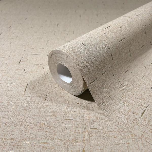 Marburg City Romance 35112 Close-up of a beige wallpaper roll on matching unrolled wallpaper, showing a fine linen-like texture with scattered short linear flecks.