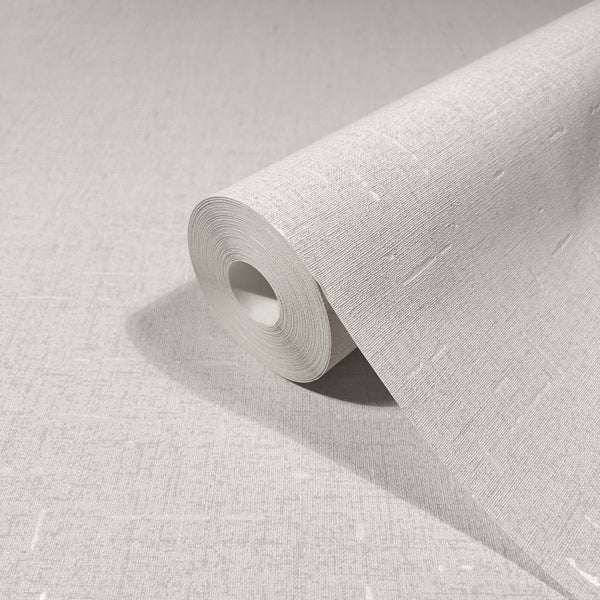 Marburg City Romance 35114 Angled roll of beige textured wallpaper with a fine linen-like weave and subtle light slubs, resting on matching unrolled wallpaper.
