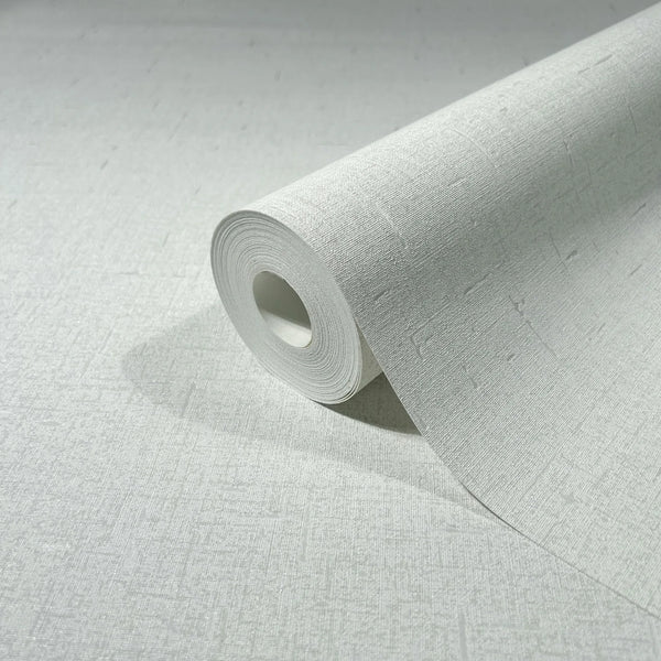 Marburg City Romance 35115 A close-up of a wallpaper roll partially unrolled on a matching light textured surface, showing a subtle crosshatch with small linear dash details.