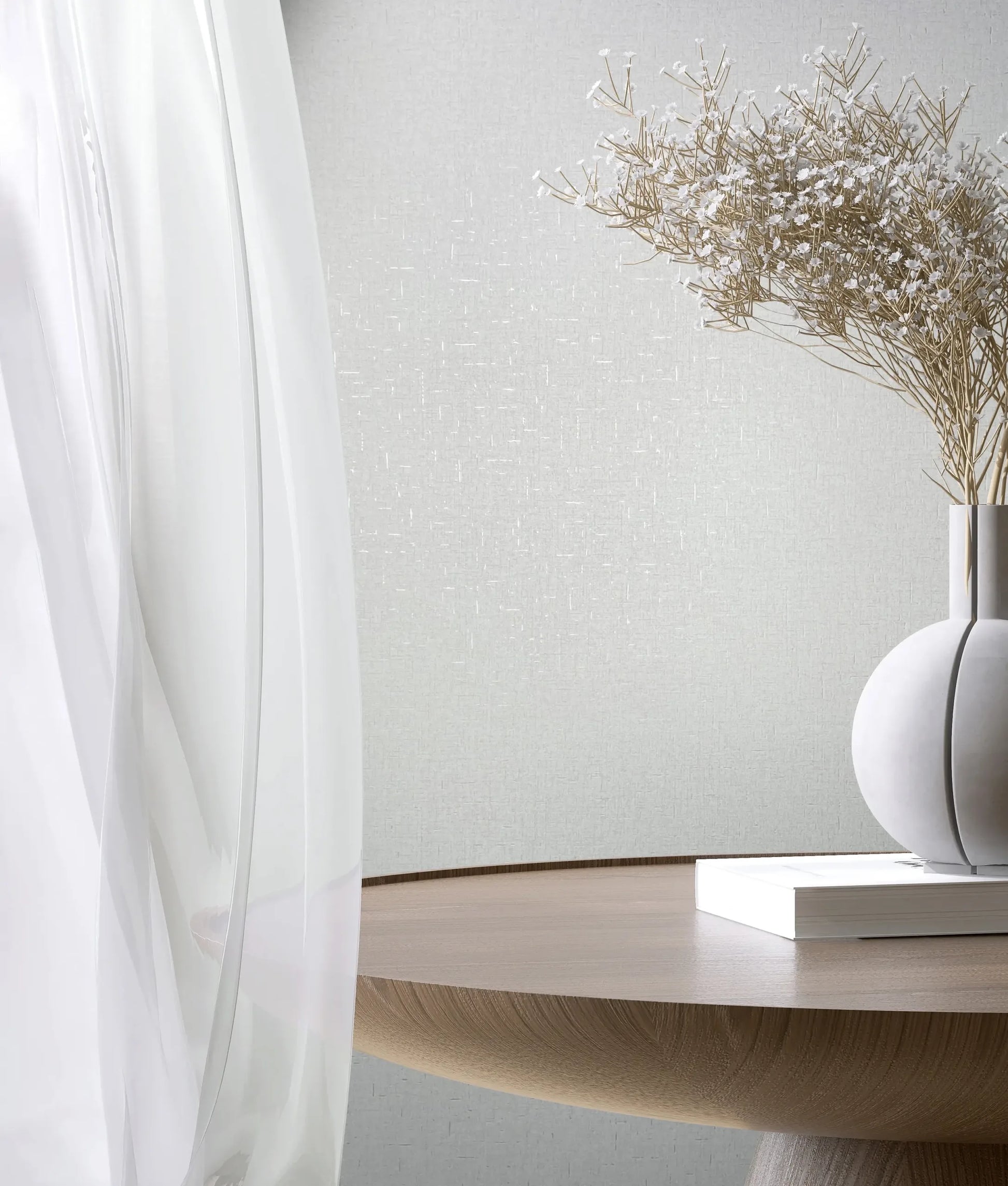 Marburg City Romance 35115 White textured wallpaper with a subtle crosshatch look behind a sheer curtain, a round wooden table, a spherical vase holding dried stems, and a closed book.