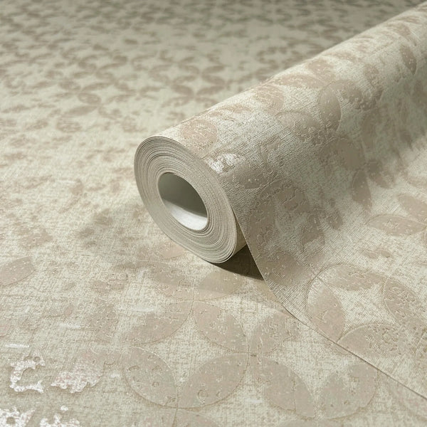 Marburg City Romance 35117 A beige wallpaper roll resting on a matching unrolled sheet, showing a subtle tonal oval or leaf pattern with a slight sheen.