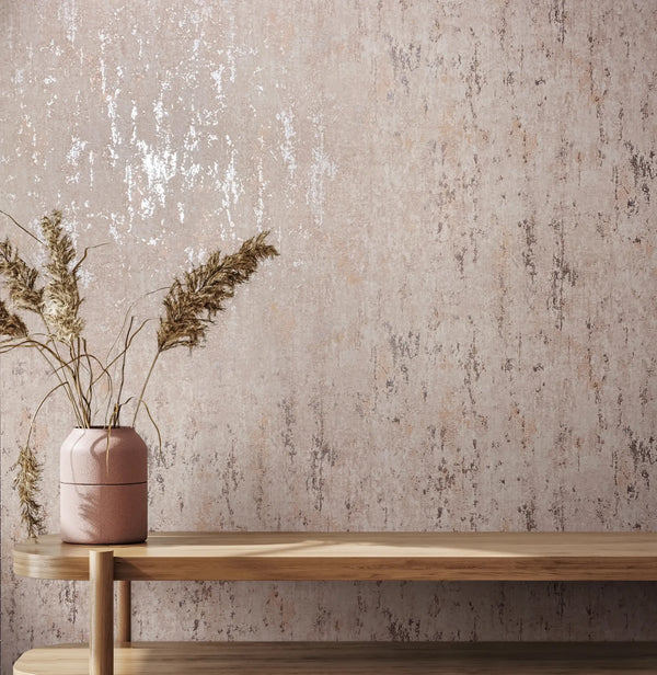 Marburg City Romance 35124 Abstract beige wallpaper with a mottled, vertically streaked texture behind a wood console holding a ceramic vase with dried grasses.