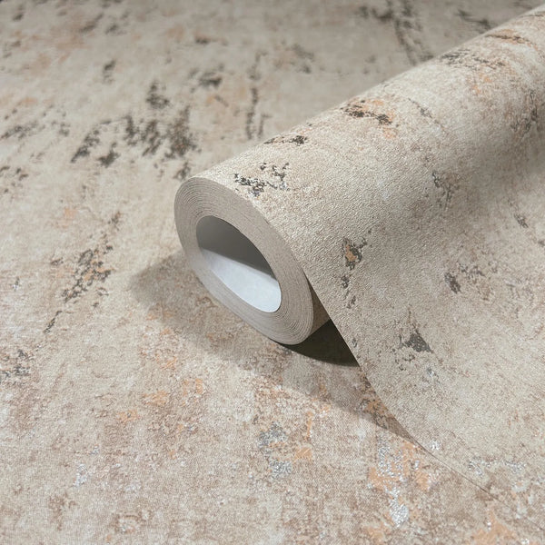 Marburg City Romance 35124 Close-up of a beige mottled, distressed-effect wallpaper shown as a partially unrolled roll on the same surface.