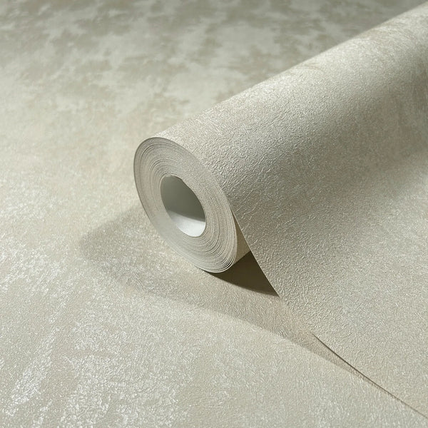 Marburg City Romance 35128 Close-up of a beige textured wallpaper roll partially unrolled on a matching surface, showing the subtle mottled pattern and light sheen.