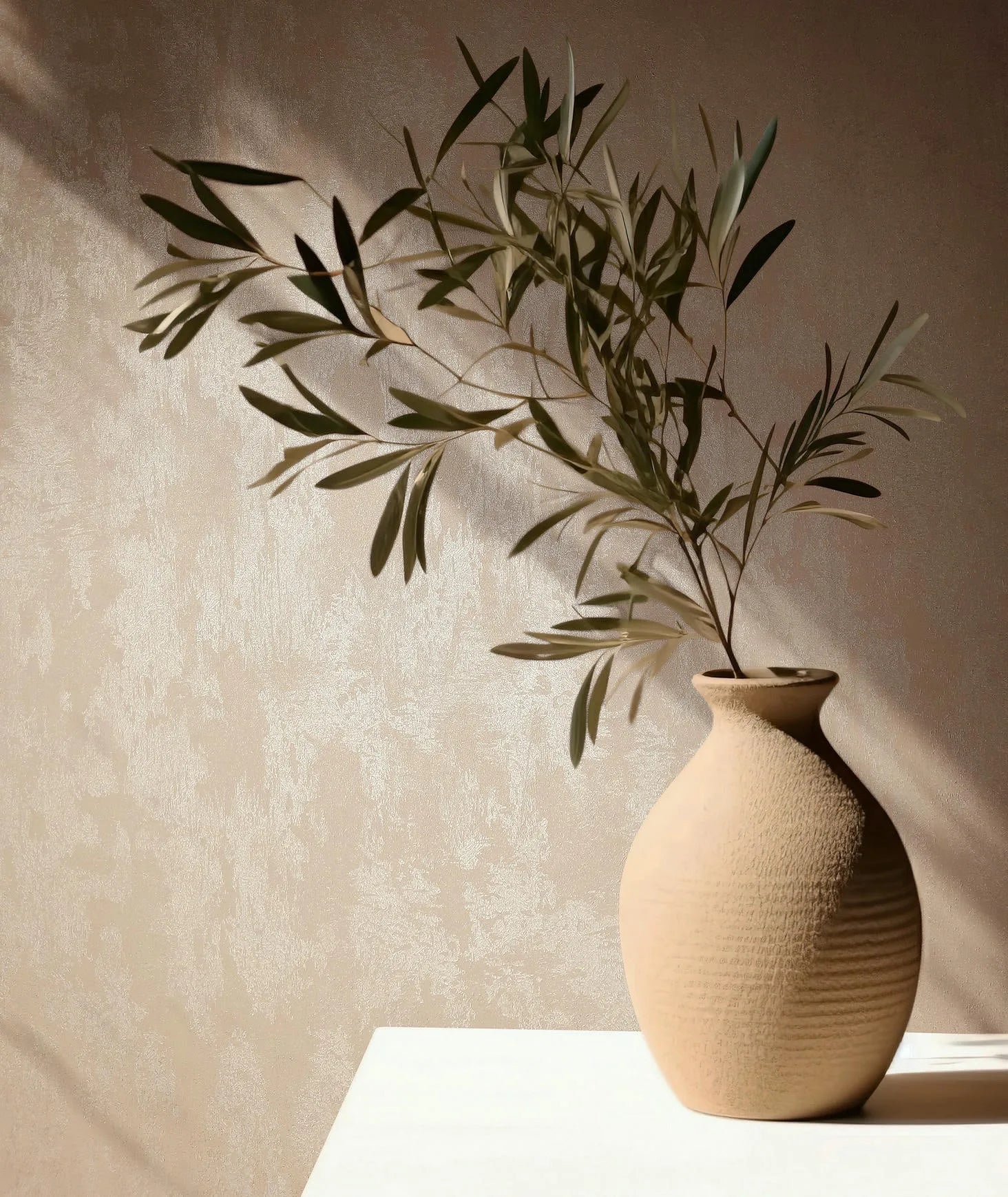 Marburg 35131 wallpaper lounge feature wall with subtle textured finish, sunlit table and ceramic vase with a leafy branch, calm and minimal.