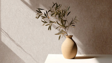 Marburg 35138 wallpaper lounge feature wall behind a sunlit side table with a ceramic vase and leafy branch, calm minimalist mood.