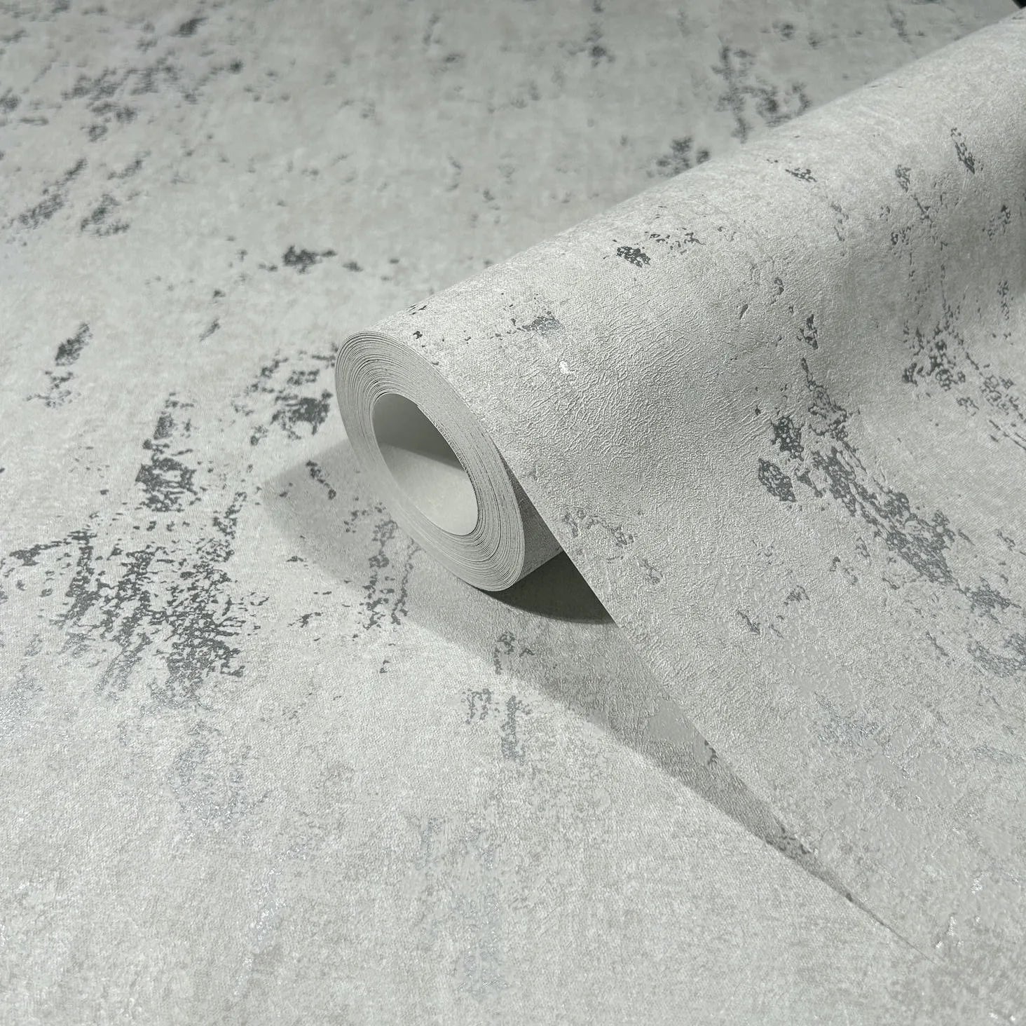 Marburg 35144 wallpaper close-up roll with textured concrete-effect pattern and scattered dark speckles.