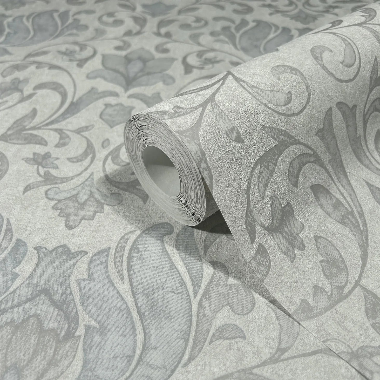 Marburg 35147 wallpaper roll close-up with large-scale scrolling floral damask pattern in light and dark grey.