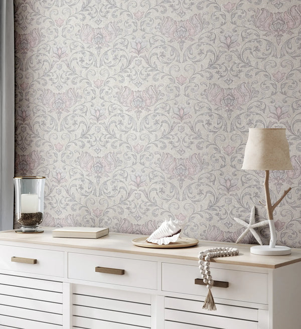 Marburg 35150 wallpaper in a lounge feature wall behind a white sideboard with candle, book, seashell tray, starfish decor, and a soft-shaded table lamp for a calm coastal mood.