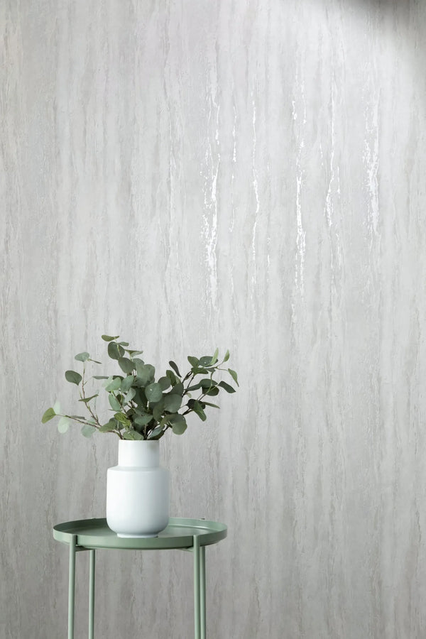 Marburg 35153 wallpaper in a lounge feature wall with subtle vertical texture behind a round side table and white vase of eucalyptus, minimal and calming.
