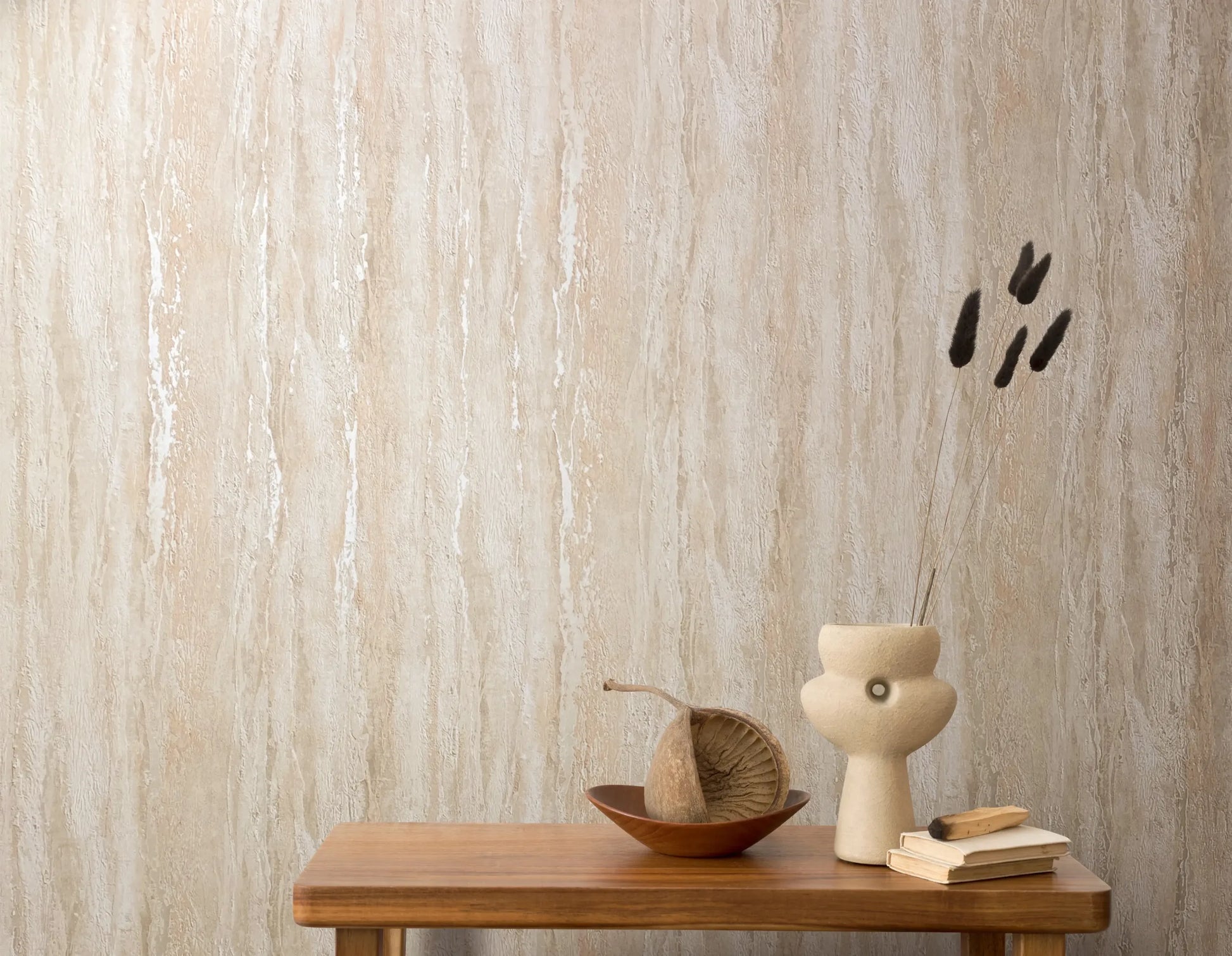 Marburg 35154 wallpaper lounge feature wall behind a wooden console table with a sculptural ceramic vase, dried stems, stacked books and a shallow bowl, serene minimalist feel.