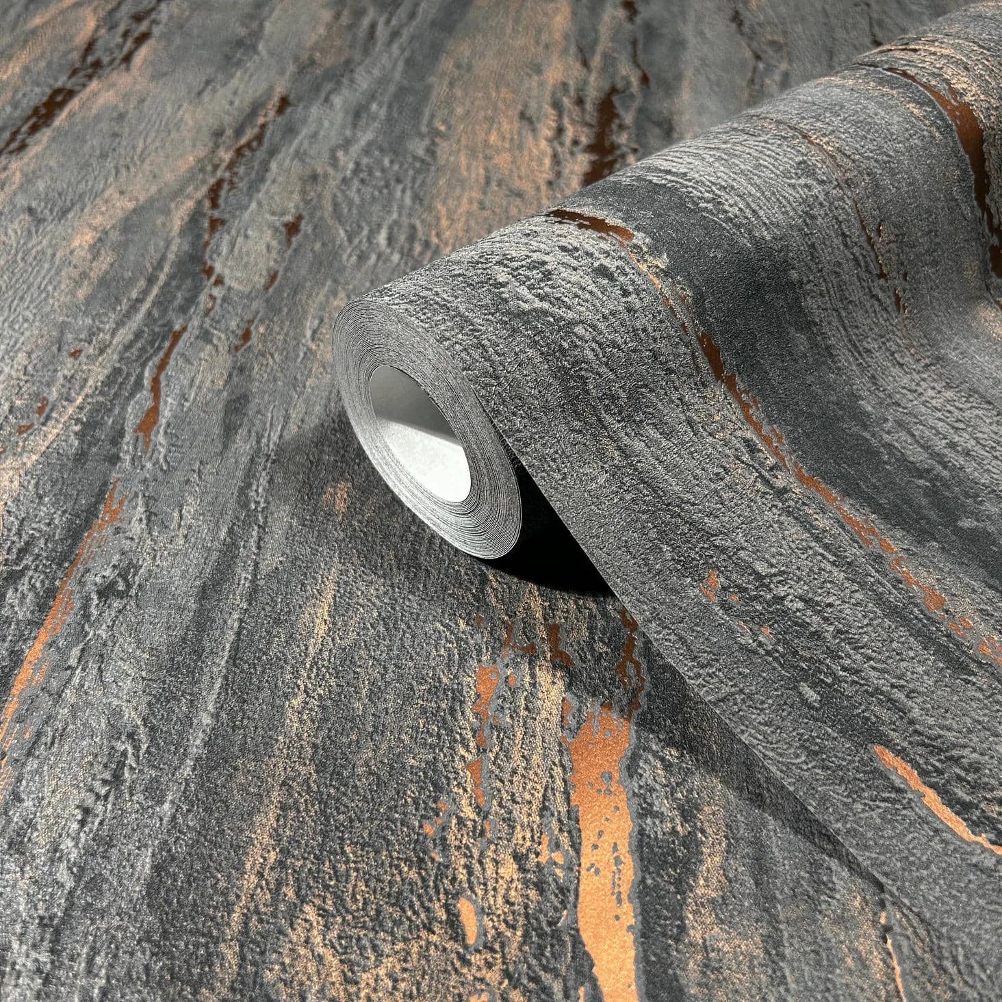 Marburg 35156 wallpaper with charcoal gray stone-like texture and metallic copper streaks, close-up detail.