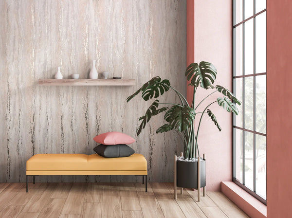 Marburg 35158 wallpaper lounge feature wall with textured neutral streaks, yellow bench with pink and charcoal cushions, floating shelf with white ceramics, tall window and potted monstera, calm modern feel.
