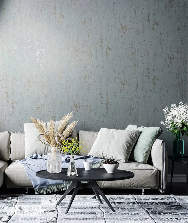 Marburg 35162 wallpaper in a lounge with a textured feature wall behind a cushioned sofa, black round coffee table with vases and pampas grass, side table with flowers, and a calm modern mood.