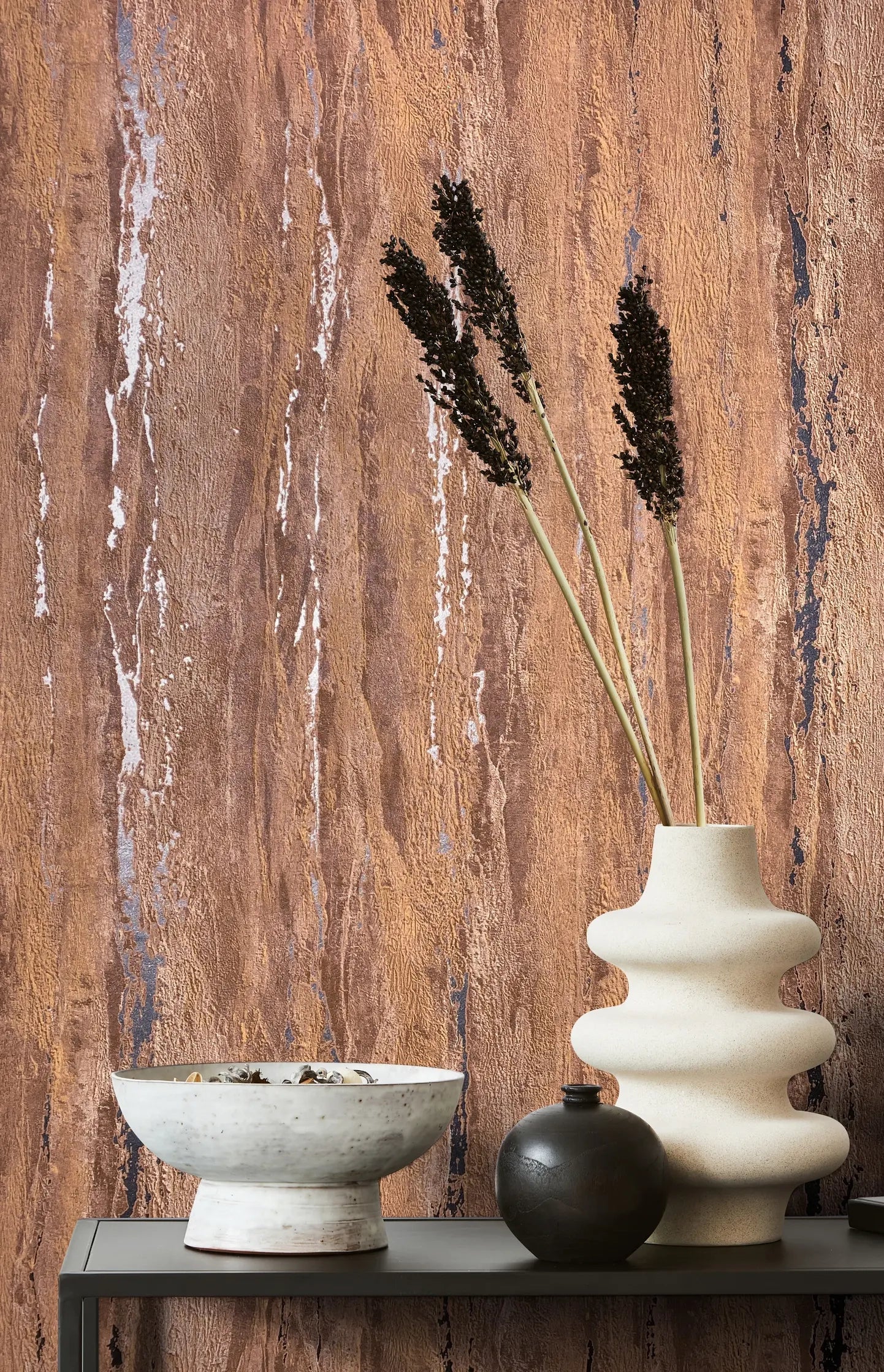 Marburg 35166 wallpaper lounge feature wall with textured abstract pattern behind a slim console styled with a sculptural vase of dried stems, a round vase, and a ceramic bowl for a calm contemporary mood.