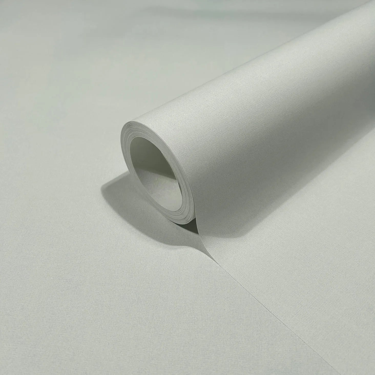 Marburg 47605 wallpaper roll close-up showing fine textured light grey surface.