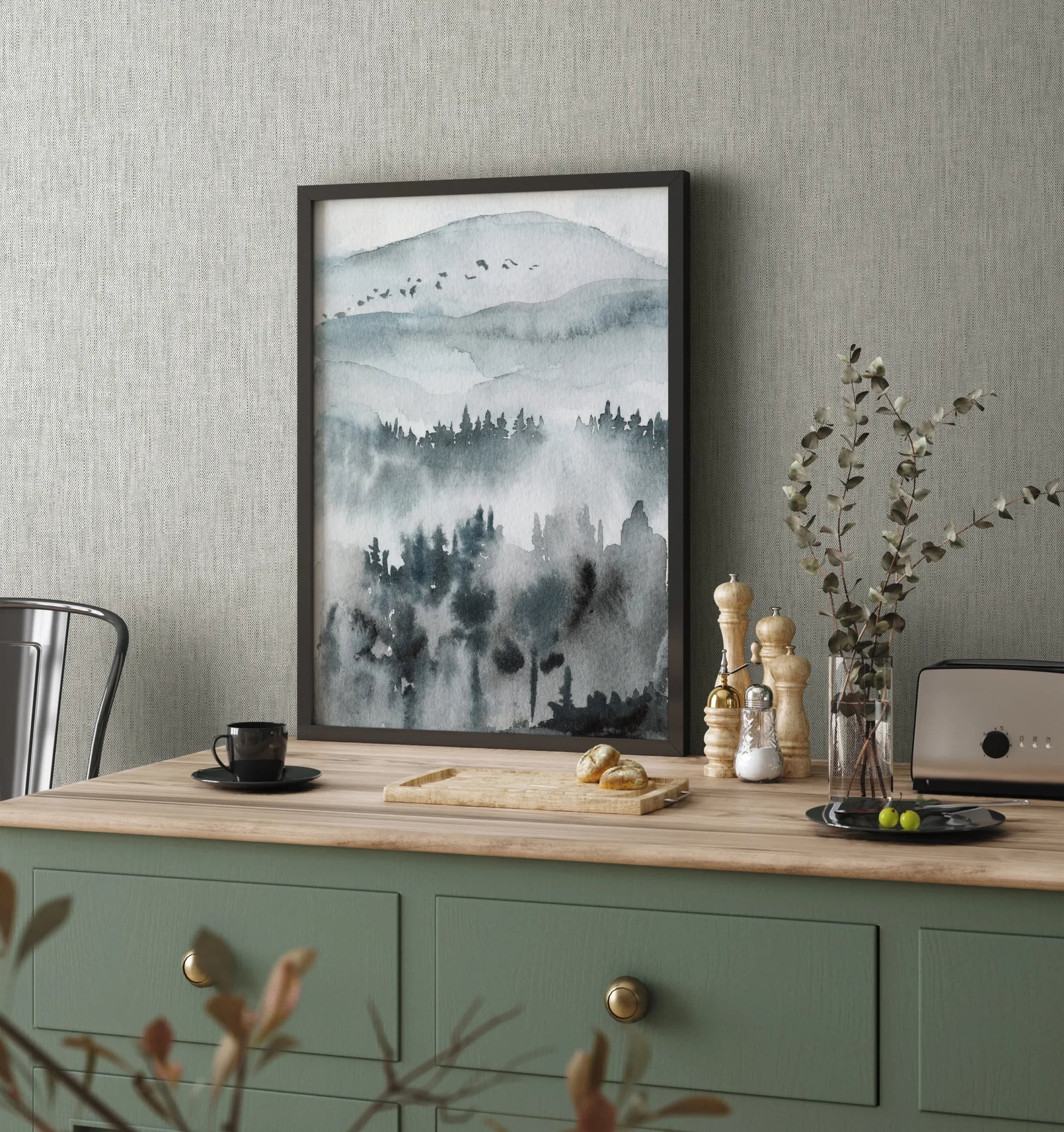 Marburg 47616 wallpaper kitchen feature wall behind a green sideboard with wood top, framed landscape art, toaster, pepper mills, vase with eucalyptus, and a cup for a calm modern mood.
