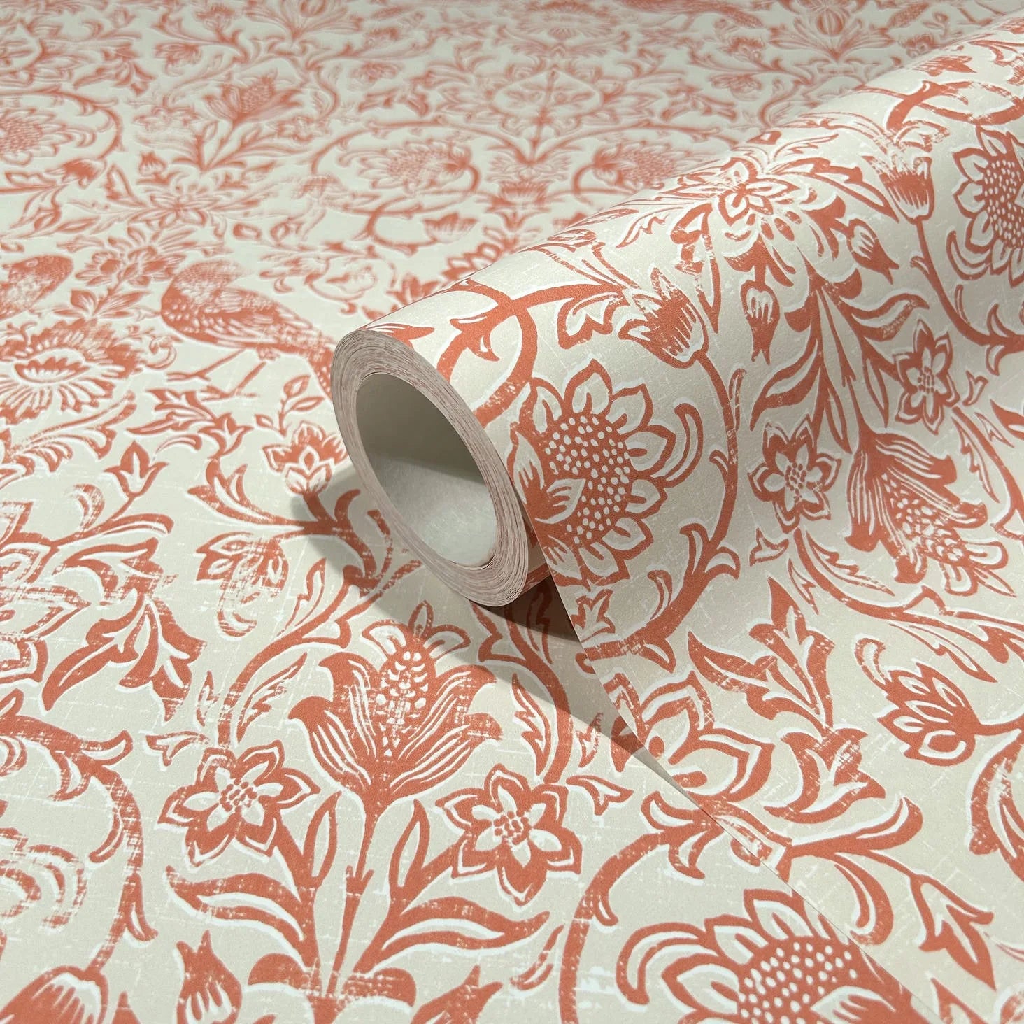 Marburg 47622 wallpaper roll close-up with rust-orange floral and bird pattern on a light background.