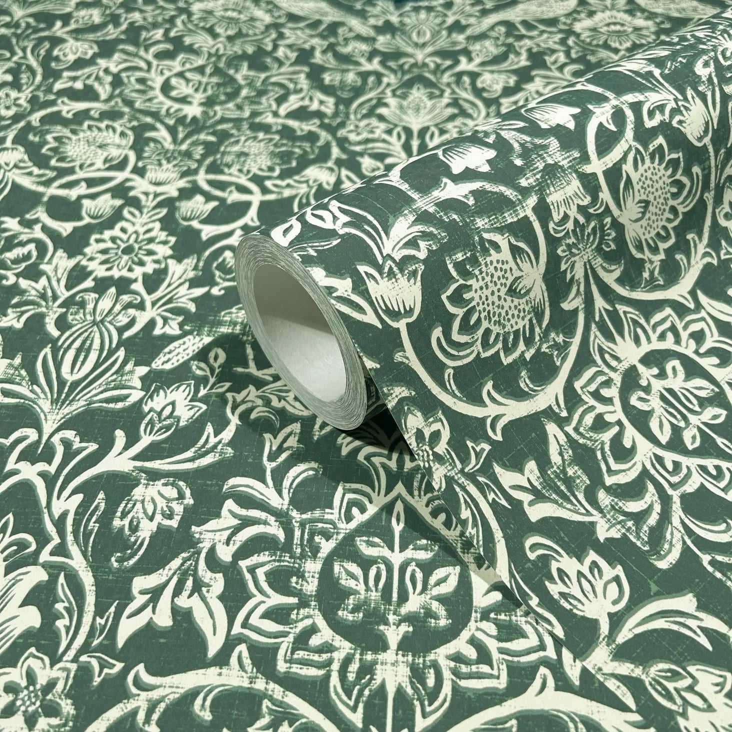 Marburg 47624 wallpaper roll close-up with white floral damask pattern on dark green.