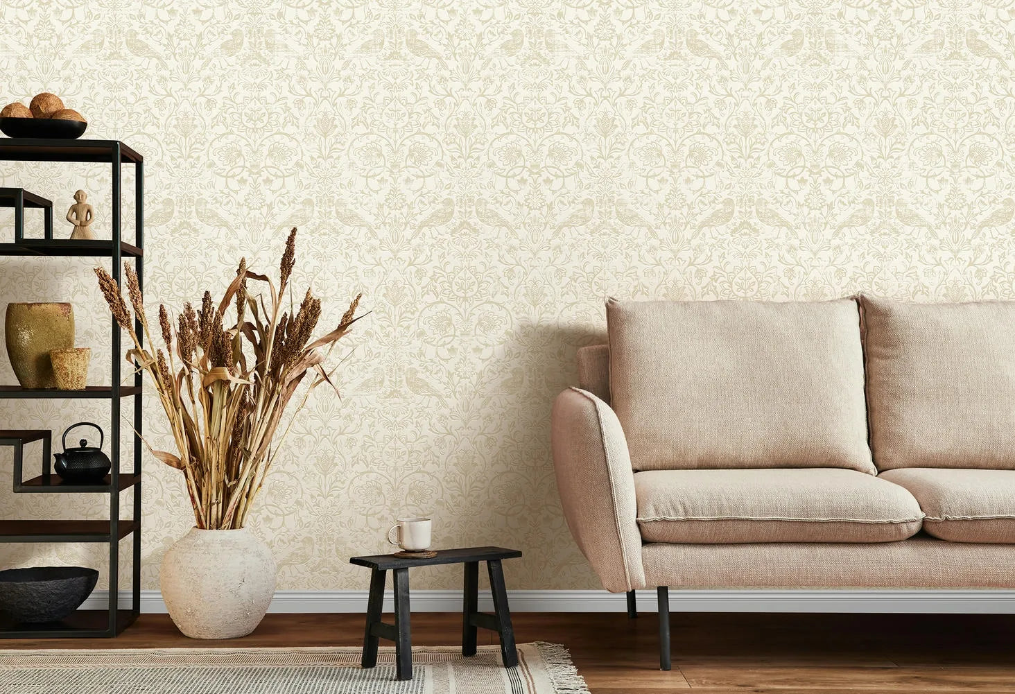 Marburg 47625 wallpaper for a lounge feature wall behind a cushioned sofa, open shelving with ceramics, a floor vase of dried grasses, and a low stool table, creating a calm minimalist mood.