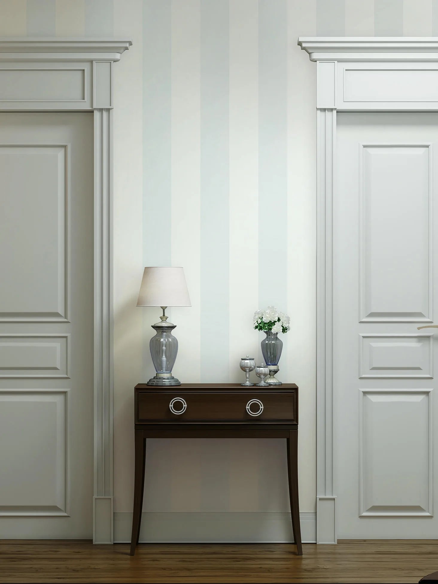Marburg 47635 wallpaper lounge feature wall with soft vertical stripes, dark wood console between paneled doors, glass lamp and vase of white flowers, calm classic feel.