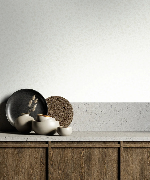 Marburg 47643 wallpaper lounge feature wall behind a slab-topped wooden sideboard with ceramic vases, a dark plate, a round woven piece, and dried stems for a calm minimalist feel.