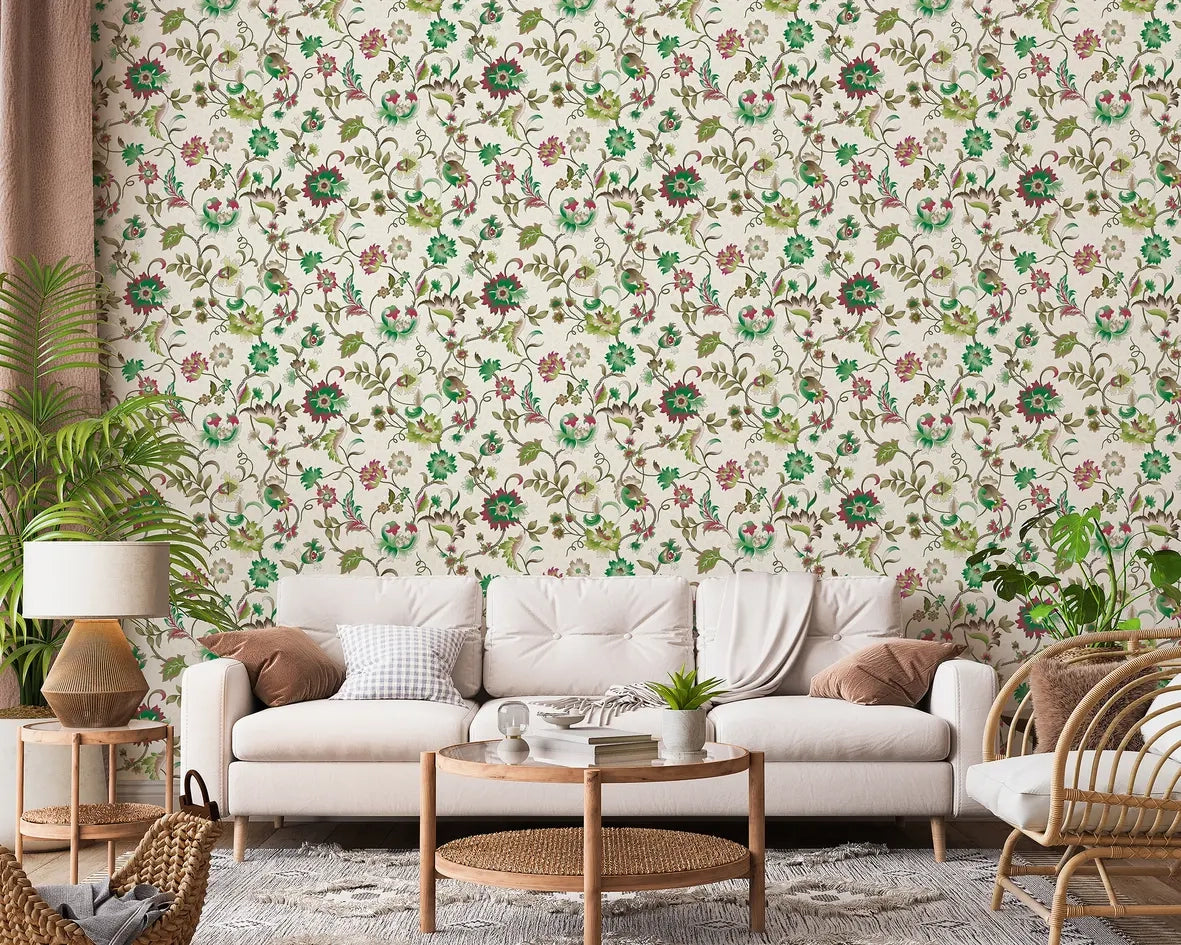 Marburg 47648 wallpaper lounge feature wall behind a light sofa with cushions, round wooden coffee table and side table, rattan chair, floor lamp and leafy houseplants for a relaxed botanical vibe.