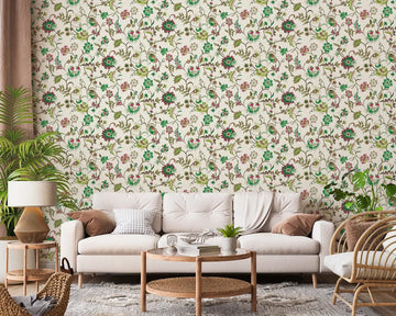 Marburg 47648 wallpaper lounge feature wall behind a light sofa with cushions, round wooden coffee table and side table, rattan chair, floor lamp and leafy houseplants for a relaxed botanical vibe.