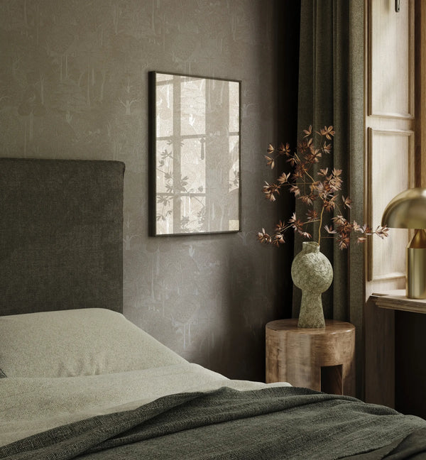 Marburg 47649 wallpaper in a calm bedroom feature wall behind an upholstered headboard, with framed art, a round wooden side table, a sculptural vase with branches, and a lamp by the window.