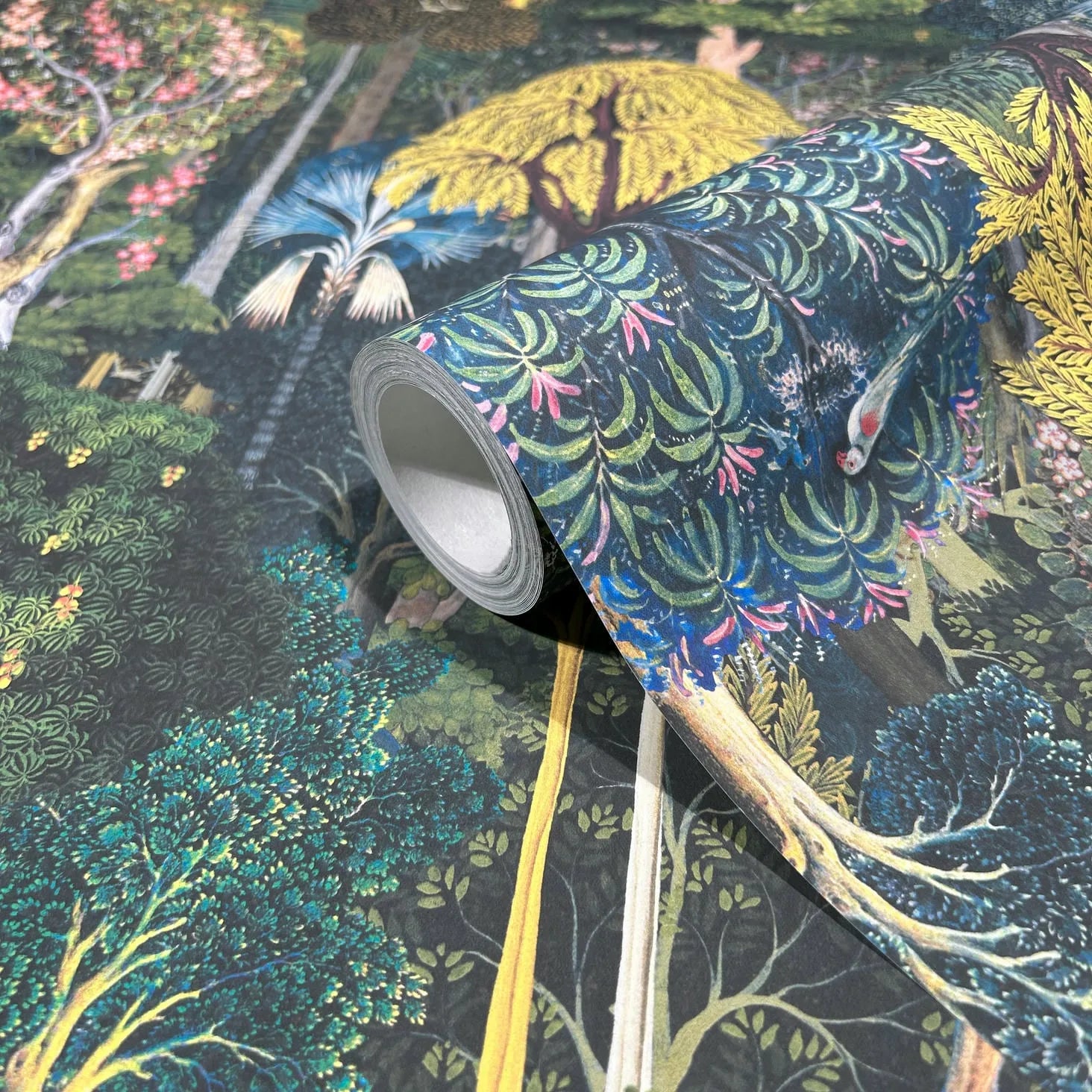 Marburg 47650 wallpaper roll close-up with lush forest illustration of trees, foliage, and birds.
