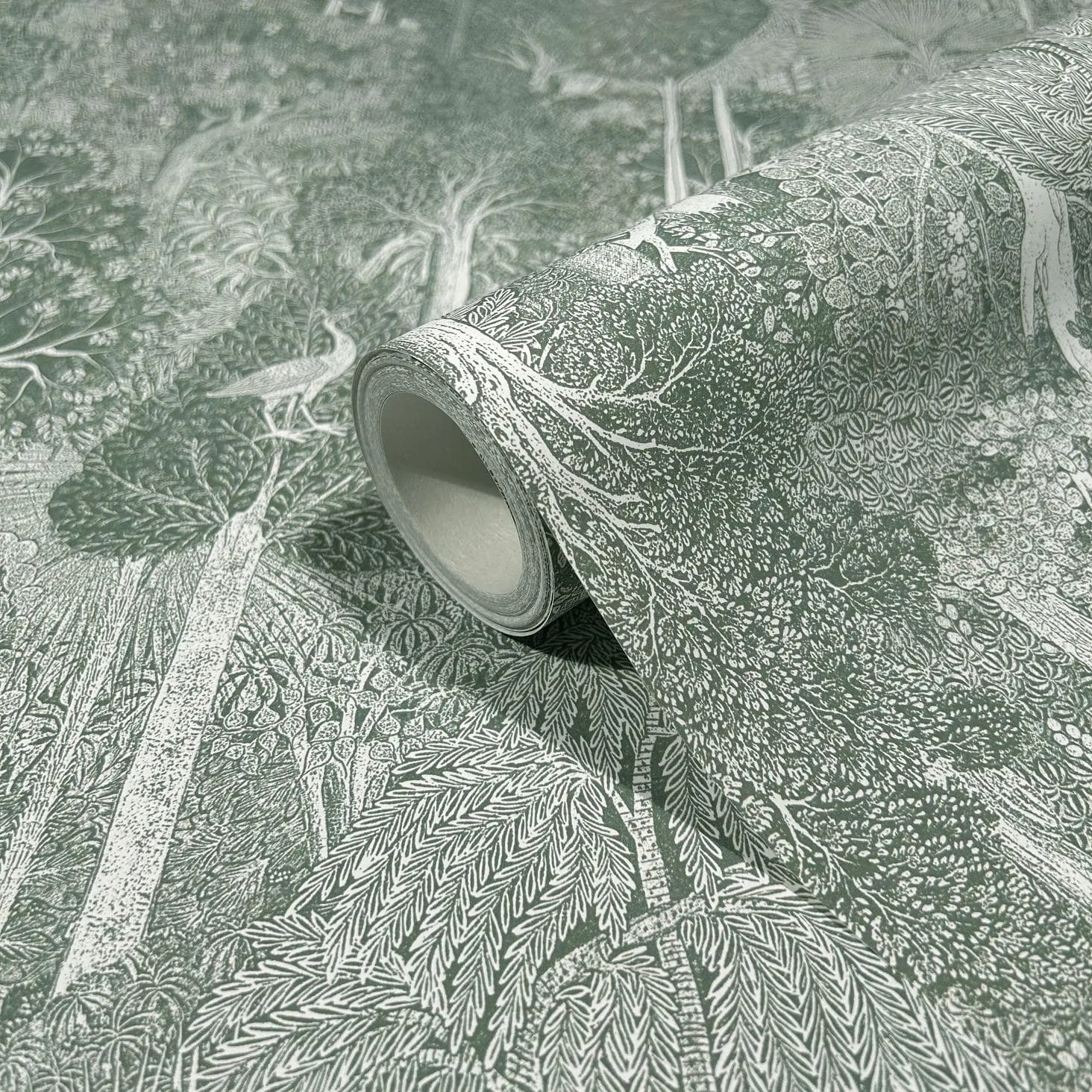Marburg 47651 wallpaper roll close-up with intricate forest foliage and bird motif, unrolled on flat surface.