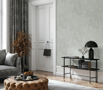 Marburg 47653 wallpaper in a modern lounge feature wall with black console and sculptural lamp, grey sofa and tufted ottoman coffee table, dried grass by paneled doors, calm and refined.