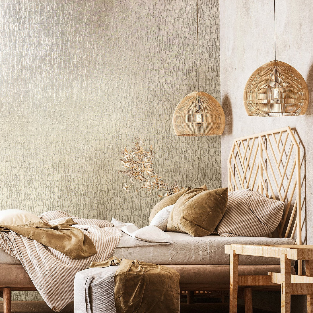 Marburg Kumano 34502 Bedroom scene featuring light beige-gray textured wallpaper with an organic crackle pattern behind a low bed with a wood geometric headboard, two rattan pendant lights, a small bench, and layered bedding.