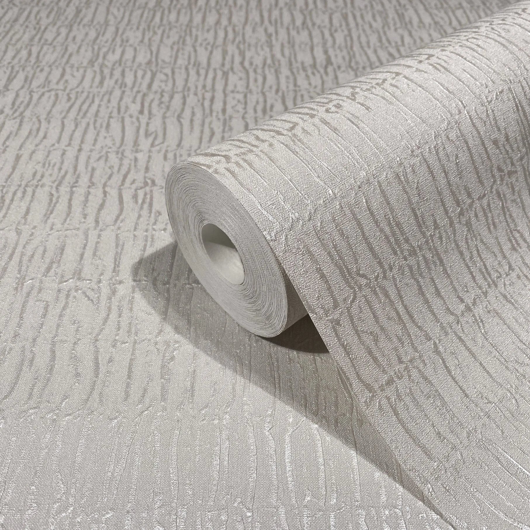 Marburg Kumano 34503 A gray wallpaper roll on a matching surface, showing an embossed irregular vertical line texture.