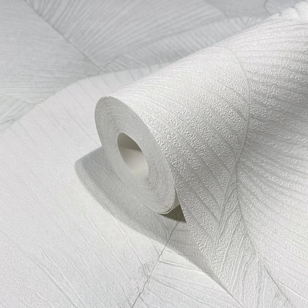 Marburg Kumano 34507 Close-up of a white textured wallpaper roll showing an embossed leaf-like linear pattern, resting on matching unrolled wallpaper.