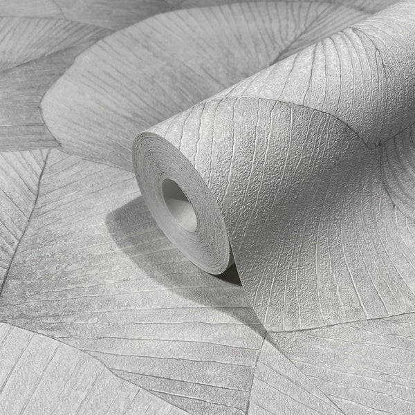 Marburg Kumano 34509 Close-up of a gray wallpaper roll with a large fan-like leaf pattern and raised texture, resting on matching unrolled wallpaper.