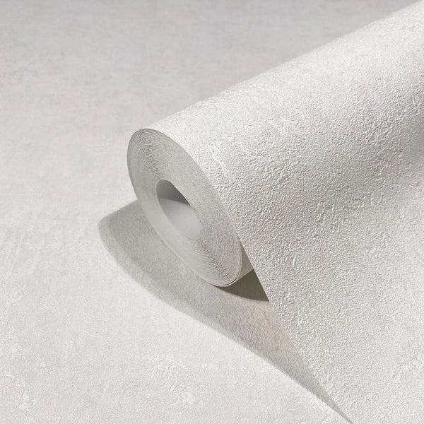 Marburg Kumano 34517 Close-up of a white textured wallpaper roll with a subtle plaster-like pattern, partially unrolled on a matching surface.