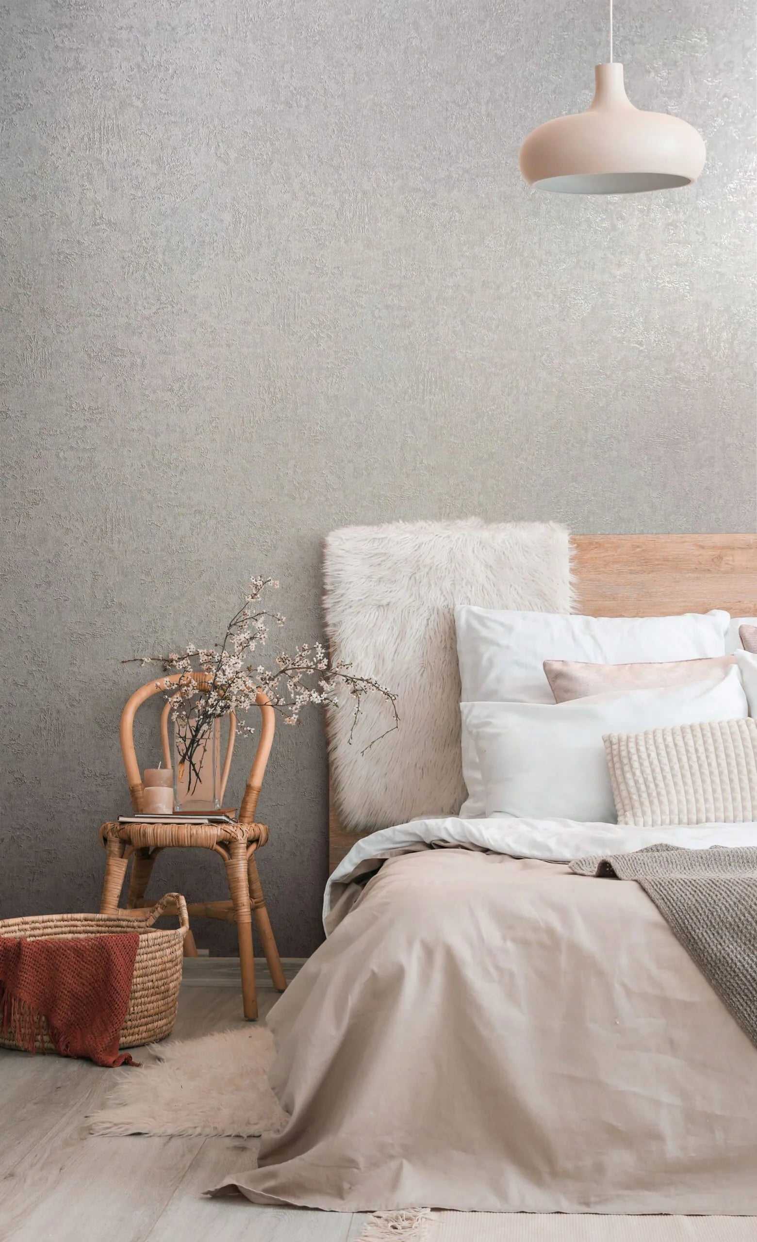 Marburg Kumano 34519 A bedroom scene with gray textured wallpaper behind a wooden headboard, a wicker chair with branches, a pendant light, and a woven basket on the floor.