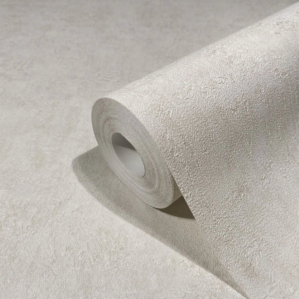 Marburg Kumano 34520 Close-up of a light beige textured wallpaper roll resting on a matching unrolled sheet, showing the subtle plaster-like texture.