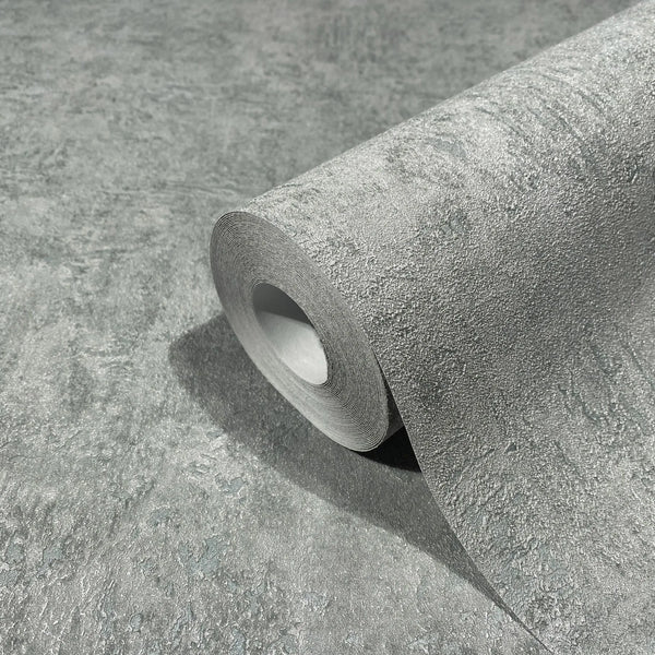 Marburg Kumano 34523 Close-up of a blue-gray textured wallpaper roll resting on a matching unrolled sheet, showing a stone-like pattern with a subtle sheen.