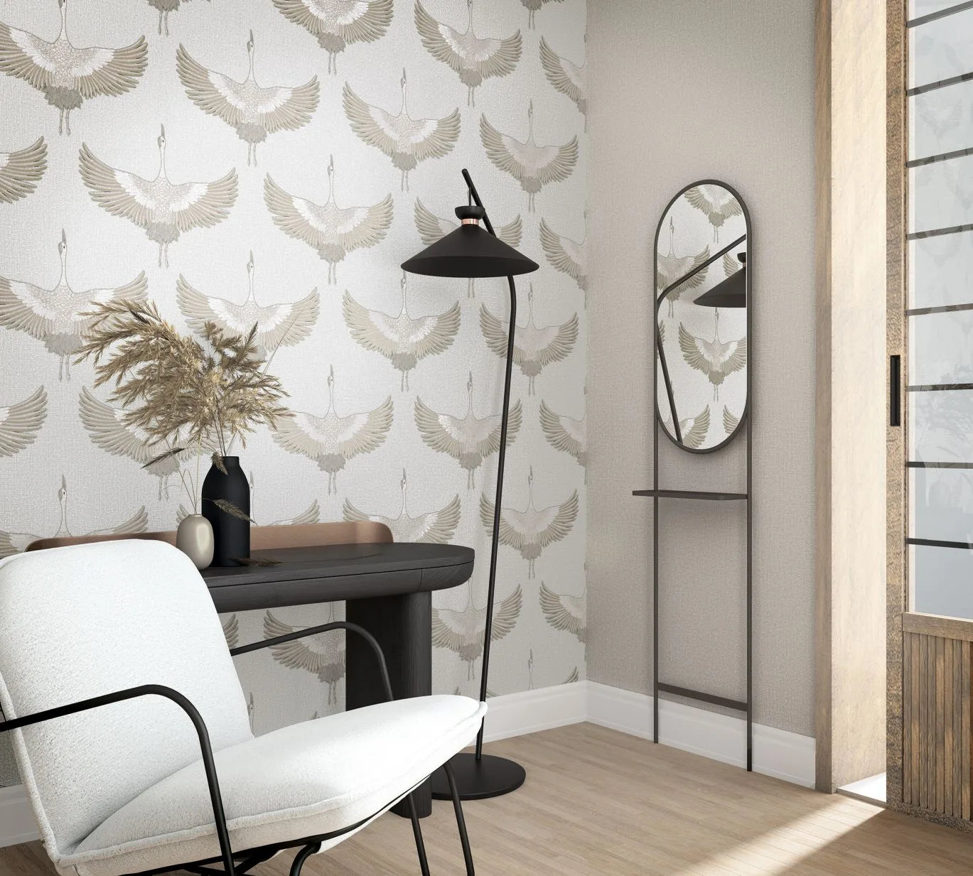 Marburg Kumano 34529 Corner scene with beige-and-white crane pattern wallpaper behind a dark console table with vases, a black floor lamp, an oval wall mirror with a small shelf, and a white chair beside a sliding door.