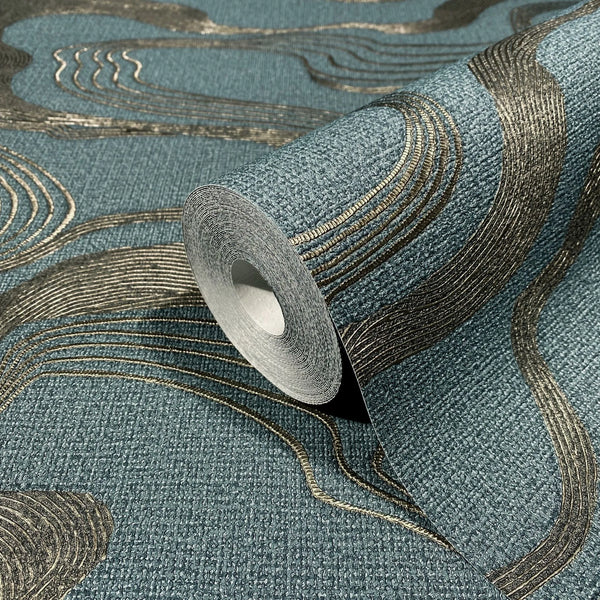 Marburg Kumano 34538 Close-up of a blue textured wallpaper roll with raised metallic gold curved lines, shown partially unrolled on matching wallpaper.